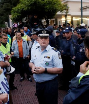Greek police officers stand opposite their colleagues guarding the parliament main entrance during a demonstration marking a 24-hour general strike against the latest round of austerity in Athens